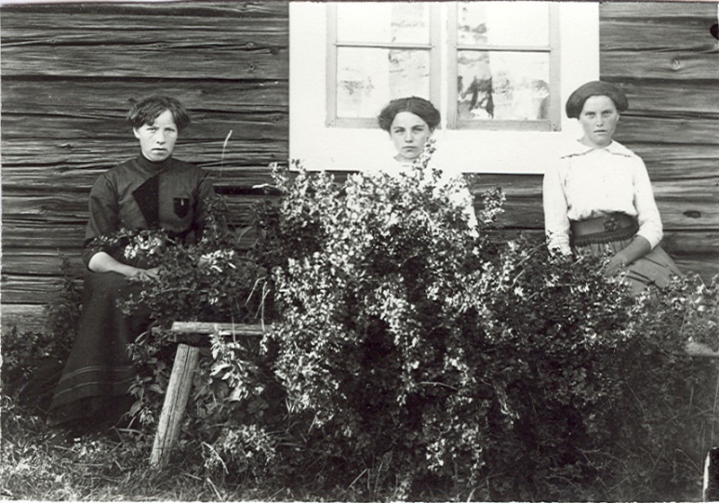 Tre kvinnor framför huset